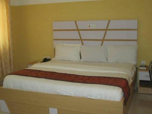 a bedroom with a large bed with white sheets and pillows at Joy House Hotel - Solace in Abuja
