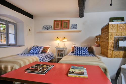 pokój z 2 łóżkami i czerwonym stołem w obiekcie Rusty's Cottage w mieście Sedlčany