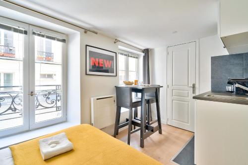 un salon avec une table et une cuisine dans l'établissement New and Bright Studio in the Heart of Paris (1G), à Paris