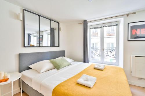 une chambre avec un grand lit avec deux serviettes dessus dans l'établissement New and Bright Studio in the Heart of Paris (1G), à Paris