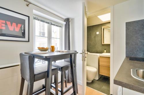 Il comprend une petite cuisine avec une petite table et une salle de bains. dans l'établissement New and Bright Studio in the Heart of Paris (1G), à Paris