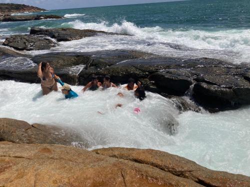 a group of people playing in the water on the beach at Cobertura com área privativa,a melhor Vista. in Cabo de Santo Agostinho