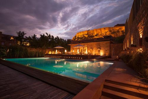 una piscina di fronte a un edificio di notte di RAAS Jodhpur a Jodhpur