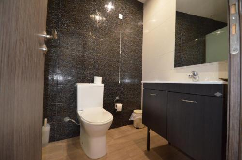 a bathroom with a toilet and a sink and a mirror at Sevastos Studios in Faliraki