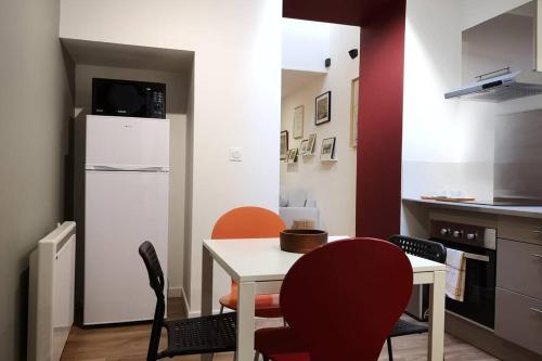 une cuisine avec une table, des chaises et un réfrigérateur dans l'établissement Le Duplex des QUAIS, à Blois