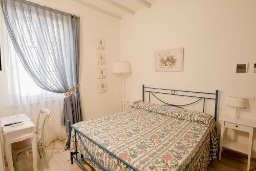 a bedroom with a bed and a table and a window at Agriturismo San Galgano in Chiusdino