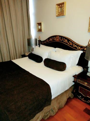 a bedroom with a large bed with white sheets and pillows at Owu Crown Hotel - Regular in Ibadan