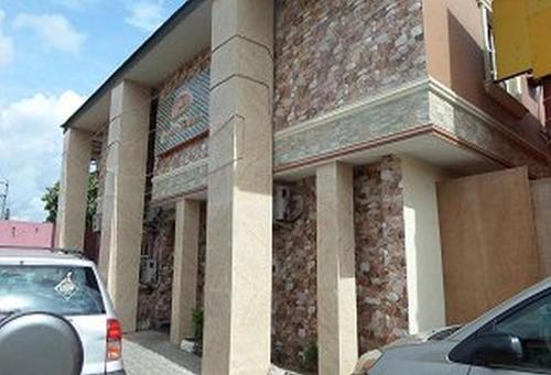 a car parked in front of a brick building at Owees Place-standard in Lagos