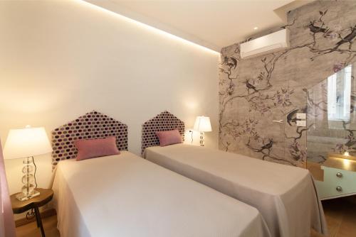 two beds in a small room with two lamps at Villa Francesca Relais in Gradara