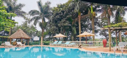 a large swimming pool with chairs and umbrellas at Jinja Nile Resort in Jinja
