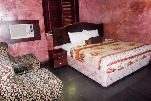 a hotel room with two beds and a chair at Room in Lodge - Suite Las Caracas-yaba in Lagos