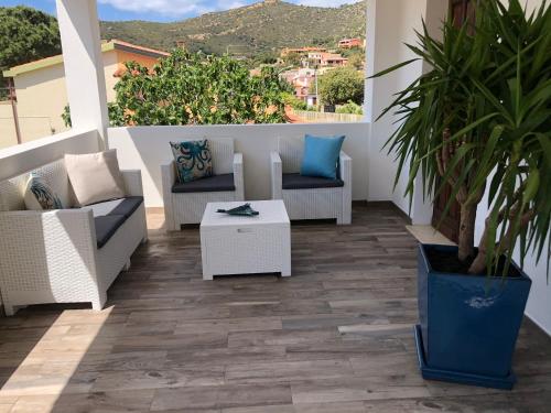 a patio with couches and a table on a balcony at Casa Babila 100 metres from the beach 10 kilometres from Villasimius in Solanas