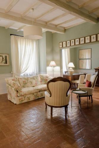 a living room with a couch and chairs and a table at Agriturismo San Galgano in Chiusdino