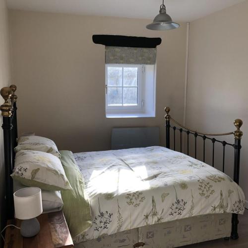 une chambre avec un lit avec une couette et une fenêtre dans l'établissement Blacksmiths Cottage in Blanzay - 3 beds, à Blanzay