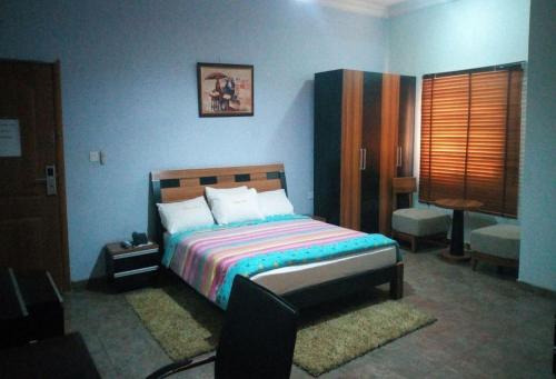 ein Schlafzimmer mit einem Bett in einem blauen Zimmer in der Unterkunft Room in Lodge - Wetland Hotels, Ibadan in Ibadan