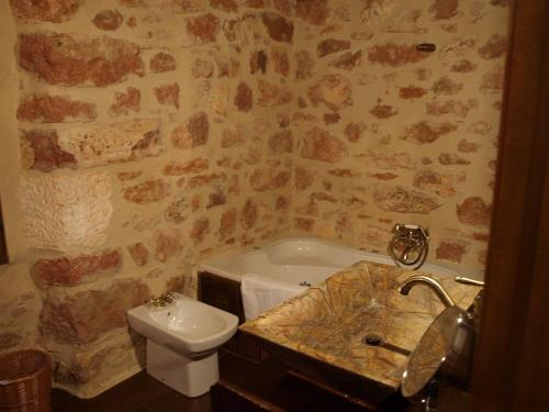 ein Badezimmer mit einem Waschbecken, einem WC und einer Badewanne in der Unterkunft El Señorio De La Serrezuela in Aldeanueva De La Serrezuela 
