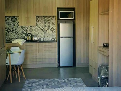 Una cocina con un refrigerador con un microondas encima. en Rand Self-catering Accommodation, en Carolina