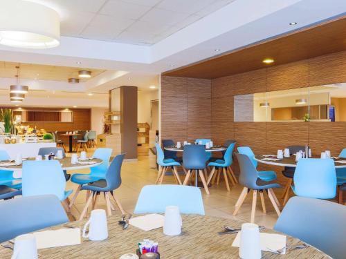 a dining room with blue chairs and tables at Mercure Paris Vaugirard Porte De Versailles in Paris