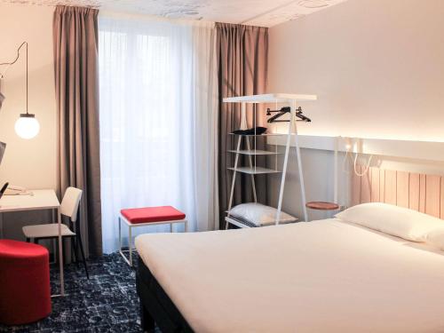 a hotel room with a white bed and a desk at ibis Lyon Centre Perrache in Lyon