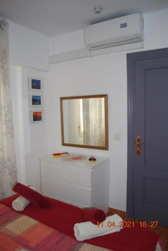 a white room with a mirror and a red blanket at Chez Alison! Central nerja apt in Nerja