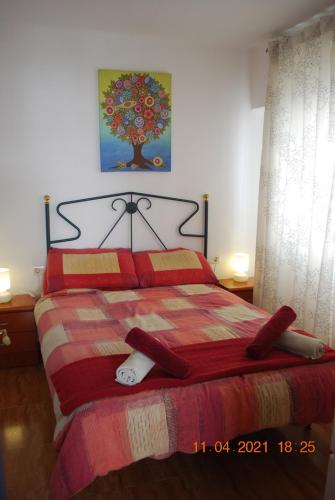 a bedroom with a large bed with a red blanket at Chez Alison! Central nerja apt in Nerja