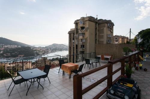 a balcony with chairs and tables and a view of a city at Guest House Barbara in Dubrovnik