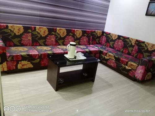 a couch in a living room with a table at Vamoose Sujata Residency in Sundargarh