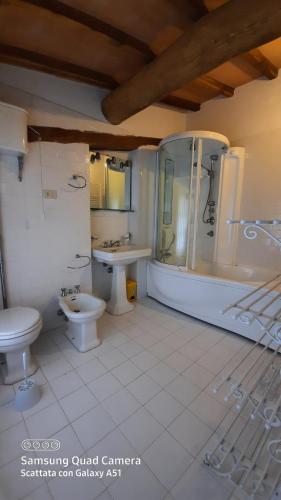 a bathroom with a toilet and a tub and a sink at Villa Lorenzo con wi-fi, aria condizionata, posto auto in Castagneto Carducci