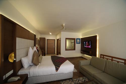 a living room with a bed and a couch at juSTa Mukteshwar Retreat & Spa in Mukteswar