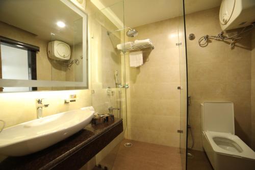 a bathroom with a sink and a glass shower at juSTa Mukteshwar Retreat & Spa in Mukteswar