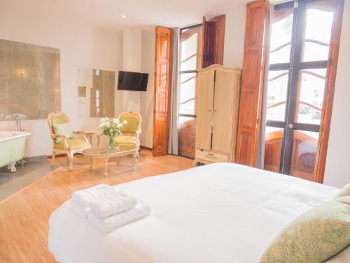 a bedroom with a bed and a bathroom with a tub at Hotel Casona 1914 in Quito