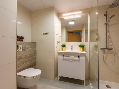 a bathroom with a shower and a toilet and a sink at VacationClub – Seaside Apartament 112 in Kołobrzeg