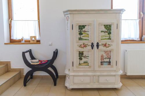 a chair and a cabinet in a room at Pensiunea Sibiel in Sibiel