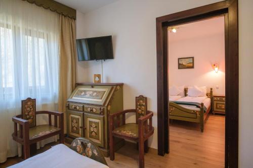 a room with a mirror and a bedroom with a bed at Pensiunea Sibiel in Sibiel