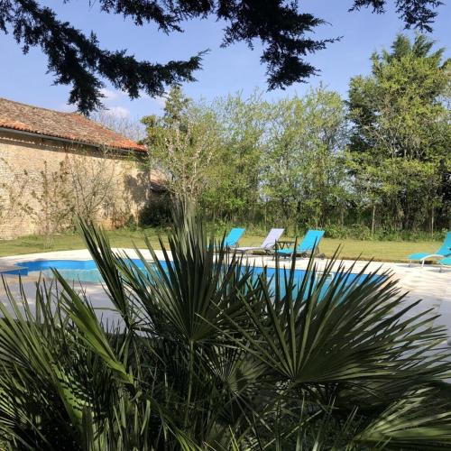 - une piscine avec deux chaises bleues dans la cour dans l'établissement BlanzayAprtment 1bed Pool Bbq Wifi FreeP, à Blanzay