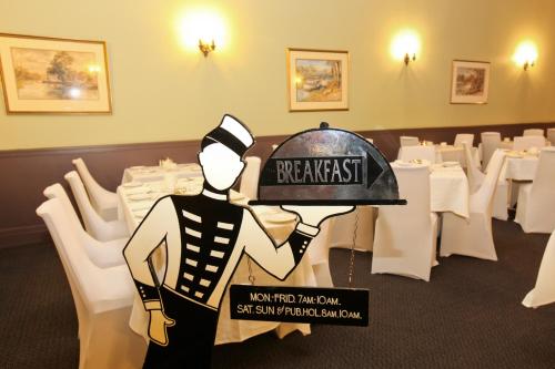 a man in a restaurant holding a sign that reads request at Quality Hotel Mildura Grand in Mildura