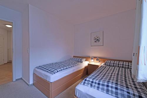 two beds in a hotel room with one bedskirts at BER-511-Appartementresidenz in Scharbeutz
