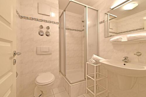 a bathroom with a shower and a toilet and a sink at BER-511-Appartementresidenz in Scharbeutz