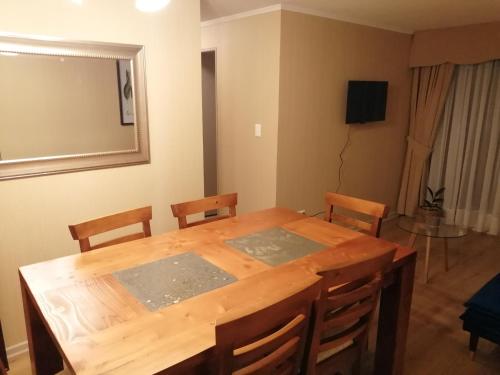 a dining room with a wooden table and chairs at Departamentos amoblados - Santa Sofia. in Concepción