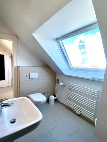 a bathroom with a sink and a toilet and a window at Haus Germania in Helgoland