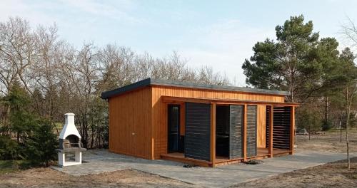 a small wooden house with a chimney and a bird house at ApartDomek CICHE in Zbiczno