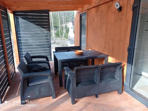 a patio with chairs and a table on a deck at ApartDomek CICHE in Zbiczno