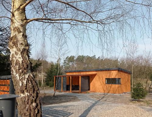 a wooden house with a black roof at ApartDomek CICHE in Zbiczno