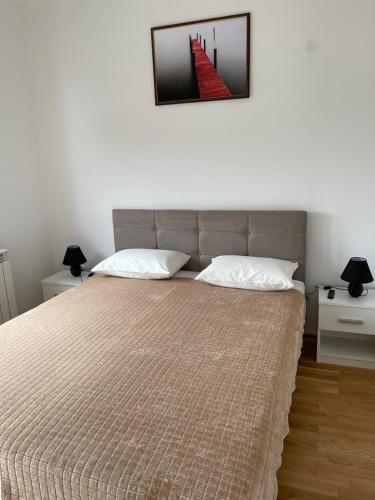 a bedroom with a bed and a picture on the wall at Royal Residence Apartmani 2 in Pančevo