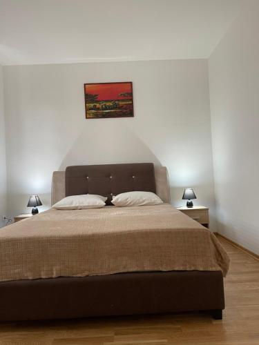 a bedroom with a large bed with two night stands at Royal Residence Apartmani 2 in Pančevo