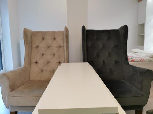 two chairs sitting next to a white table and two chairs at LUXURY APARTMENT in Warsaw