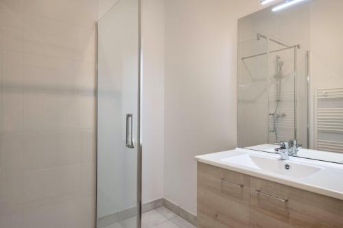 une salle de bain avec une douche en verre et un lavabo dans l'établissement À 50m de la plage, bel appartement pour 6, à Pléneuf-Val-André