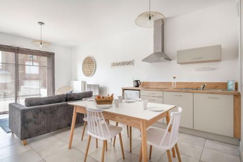 une cuisine et un salon avec une table et des chaises dans l'établissement À 50m de la plage, bel appartement pour 4, à Pléneuf-Val-André