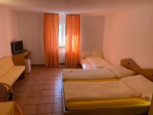 a hotel room with two beds and a tv at Ristorante Con alloggio Val Sole in Acquarossa