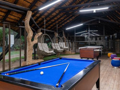 a pool table in a pavilion with chairs at Dikhololo in Brits